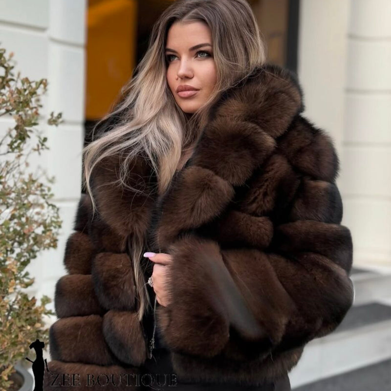 Woman wearing a brown fur coat standing outdoors.