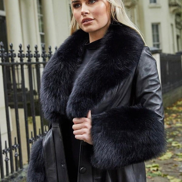Woman wearing a black leather coat with fur collar in an urban setting