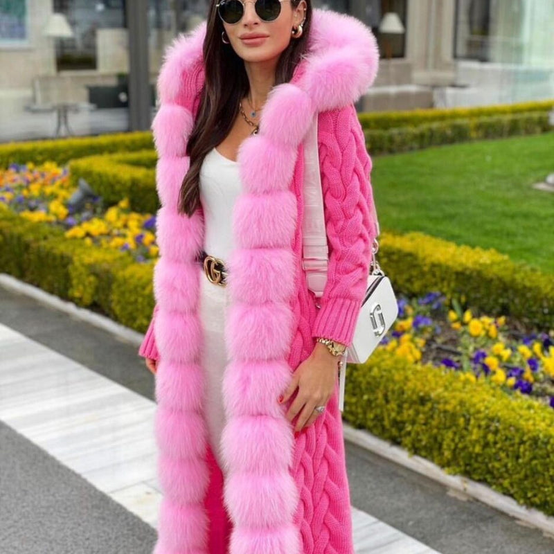 Woman wearing a long pink fur coat with a blurred outdoor background