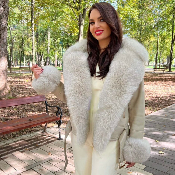 Woman wearing a light gray fur-trimmed coat in a park setting